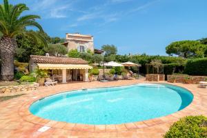 a swimming pool in front of a house at Villa au calme jardin piscine proche mer et centre ville in Vallauris