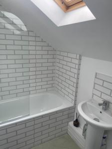 a white bathroom with a tub and a sink at Ty capel cottage in Mold +9 photos