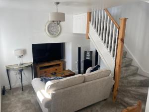 a living room with a couch and a television at Ty capel cottage in Mold