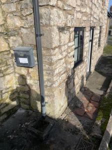 a stone wall with a box on the side of a building at Ty capel cottage in Mold
