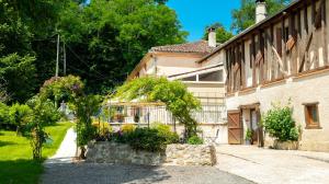 a house with flowers and plants in a yard at La Ferme des Grisettes in Montesquiou