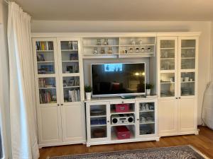 a white entertainment center with a television in it at FeWo Parkblick mit 2 Bädern in Bad Harzburg