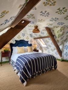 a bedroom with a blue bed in a attic at The Old Bell Hotel in Malmesbury +120 photos