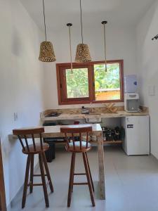 a kitchen with two wooden bar stools and a table at Casa Miava - Studio 1 - Cozy place a few meters from the beach in Marau +11 photos