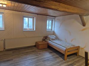 a small room with a bed and windows at Monteurzimmer 1 in Frielendorf