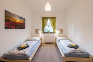 two twin beds in a room with a window at Apartmány U Parku in Vrchlabí