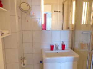 a white bathroom with a sink and a mirror at FeWo Parkblick mit 2 Bädern in Bad Harzburg +29 photos