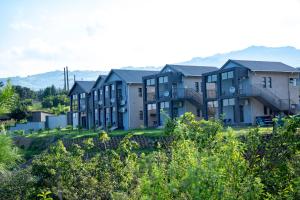 a row of apartment buildings with mountains in the background at The River Boutique Inn in Lobamba