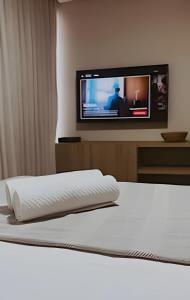 a bedroom with a bed with a tv on the wall at Get One - João Pessoa in João Pessoa