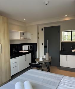 a kitchen with white cabinets and a table in a room at Get One - João Pessoa in João Pessoa