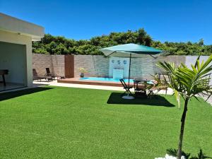 a lawn with a table and an umbrella at Espaço de descanso e paz in Cabo Frio