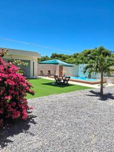 a house with a yard with a picnic table and flowers at Espaço de descanso e paz in Cabo Frio