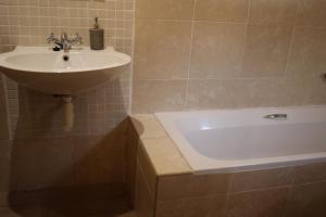a bathroom with a sink and a bath tub at Die Nagmaalhuisie in Montagu +35 photos
