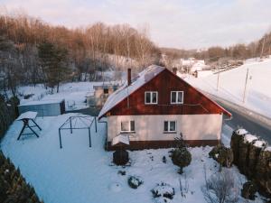 a red and white house in the snow at Domek pod lasem in Kańczuga