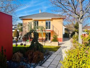 a house with a tree in the front yard at Alpine View Thierachern in Thierachern