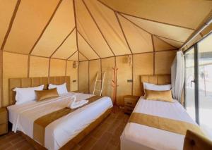 a bedroom with two beds in a tent at Sunshine luxury tent in Merzouga