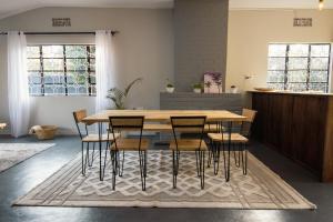 a dining room with a wooden table and chairs at Open Gate House in Arusha +9 photos