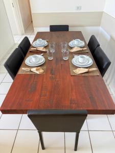 a wooden table with chairs and plates and glasses at Neo 2.0 in Maceió