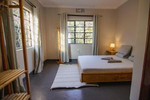 a bedroom with a bed and a window at Open Gate House in Arusha