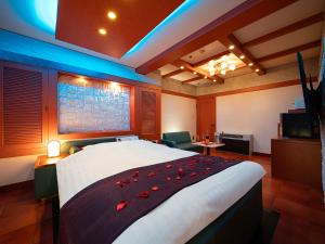 a hotel room with a large bed with red roses on it at Hotel Metro (Adult Only) in Yokohama
