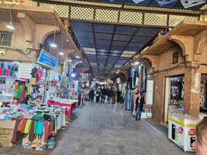 a market with people walking around in a building at Majestic Room in Agadir