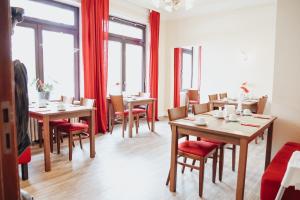 a dining room with tables and chairs and windows at Hotel Villa Kisseleff in Bad Homburg vor der Höhe