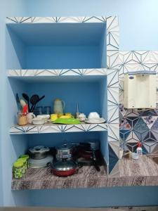 a kitchen with a blue and white tiled wall at DENEVA Inn in Nowgong +14 photos
