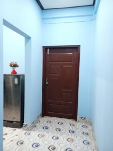 a wooden door in a room with blue walls at DENEVA Inn in Nowgong