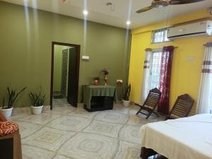a bedroom with a bed and a table in a room at DENEVA Inn in Nowgong