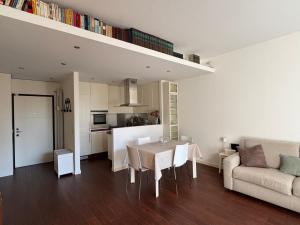 a kitchen and living room with a table and a couch at Il Giardino di Nà in Linate