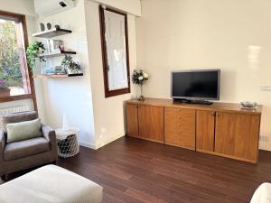 a living room with a flat screen tv on a wooden cabinet at Il Giardino di Nà in Linate