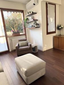 a living room with a chair and a ottoman at Il Giardino di Nà in Linate +9 photos