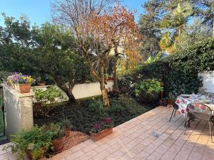 a patio with a table and some plants and trees at Il Giardino di Nà in Linate