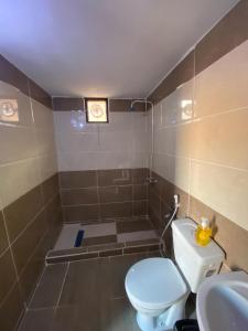 a bathroom with a toilet and a clock on the wall at Naif Bedouin tour in Wadi Rum