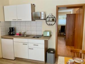 a kitchen with white cabinets and a counter top at Kleine Oase 46 in Funfseen