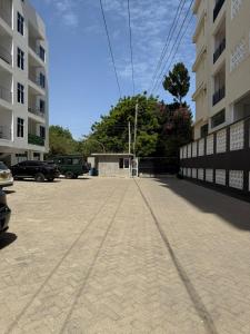 a parking lot with a fence and a building at Nyali 3 Bedroom Apartment Skyview in Mombasa
