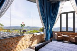 a hotel room with a bed and large windows at Sun Heaven Dalat in Xuân Trường