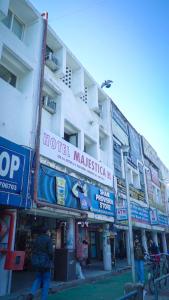 a man walking in front of a building with signs at Hotel Majestica 22 in Chandīgarh +15 photos