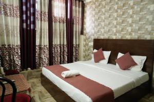 a bedroom with a bed with red and white pillows at Hotel Majestica 22 in Chandīgarh