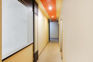 a corridor of a hallway with an orange ceiling at Hotel O Crystal in Ahmedabad