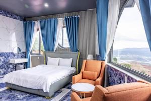 a bedroom with a bed and two chairs and a window at Sun Heaven Dalat in Xuân Trường