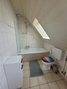 a bathroom with a toilet and a bath tub with a skylight at Ferienwohnung in Scharnebeck in Scharnebeck