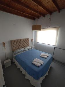 a bedroom with a blue bed with towels on it at Casa Saavedra in Dolores