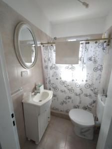 a bathroom with a sink and a toilet and a mirror at Casa Saavedra in Dolores