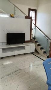 a living room with a tv and a staircase at Roshni Apartment - Ground Floor in Vishāram