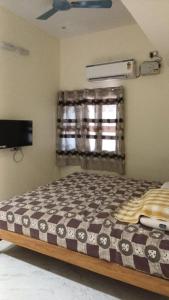 a bedroom with a bed and a window at Roshni Apartment - Ground Floor in Vishāram