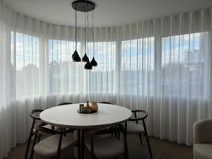 a dining room with a white table and chairs at Pirate, op 100 meter van strand in Koksijde +9 photos