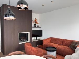 a living room with a couch and a tv at Pirate, op 100 meter van strand in Koksijde