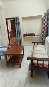 a living room with a couch and a table at Roshni Apartment - Ground Floor in Vishāram