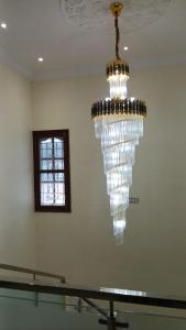 a chandelier hanging from the ceiling in a room at Roshni Apartment - Ground Floor in Vishāram